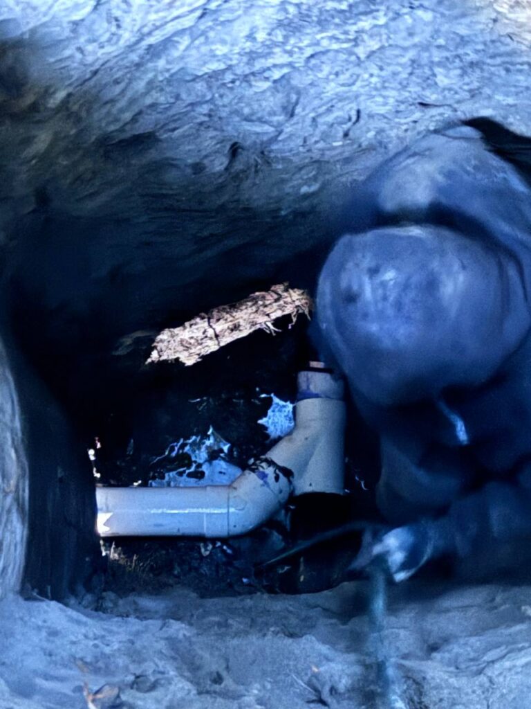 Technician repairing a submerged water pipe with safety gear and proper equipment