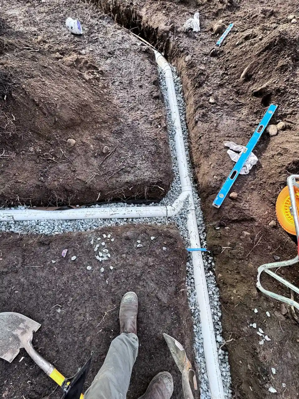 Perimeter drainage installation beside a building foundation