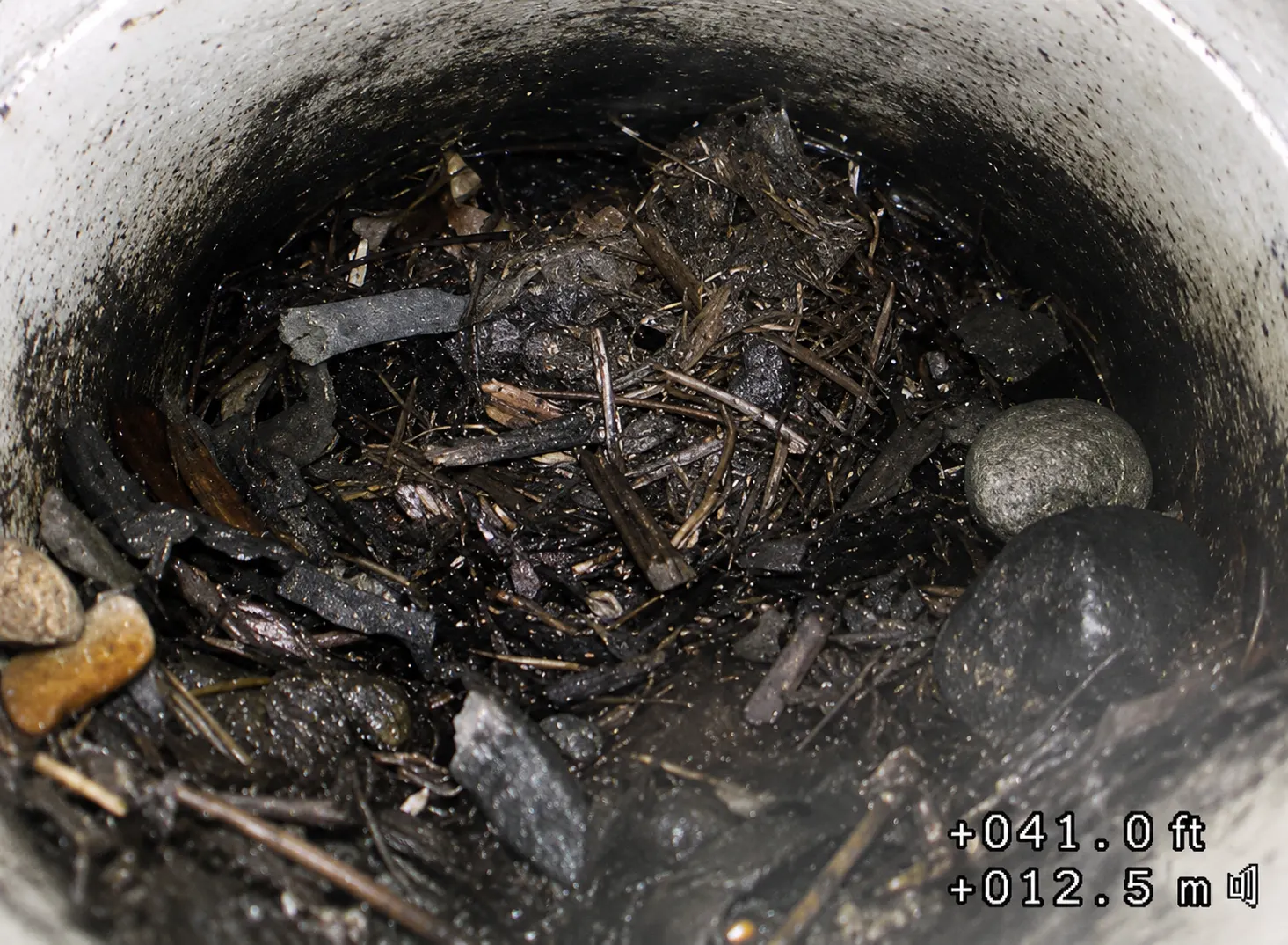Clogged underground drainage pipe filled with debris