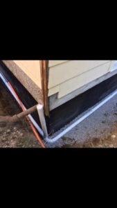 Exterior French drain installed along a residential foundation to improve drainage in Vancouver, BC.