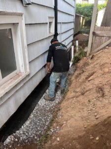 Vancouver drainage experts installing drain tile beside a residential foundation in Vancouver, BC.