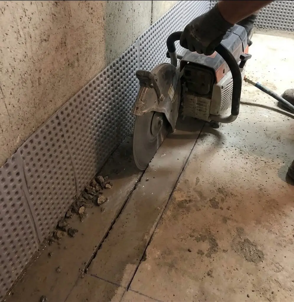Cutting the concrete basement floor for interior drainage installation