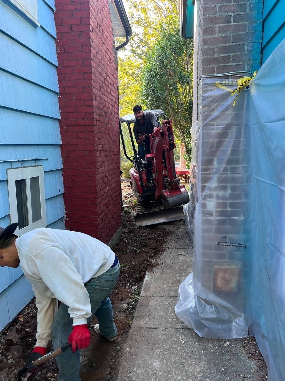 Excavating a trench along a foundation for perimeter drain installation