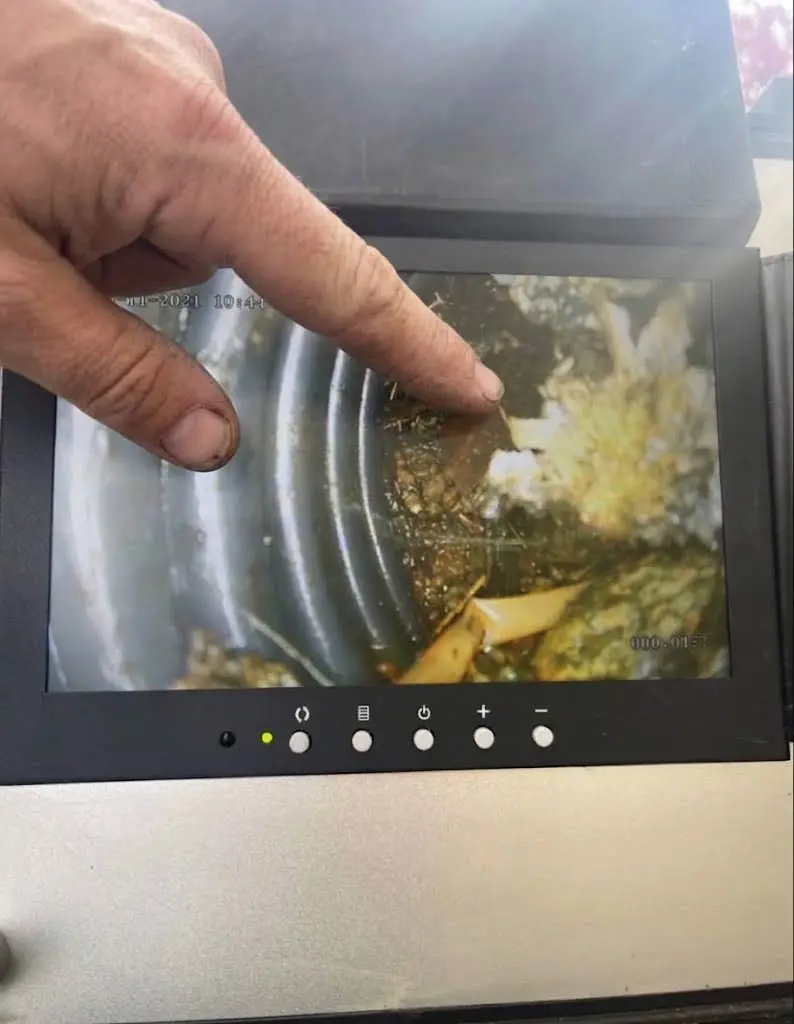 Drainage technician explaining camera inspection findings