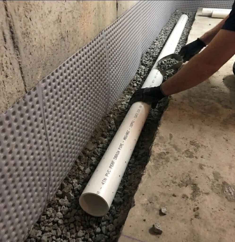 Installing interior basement drainage pipe