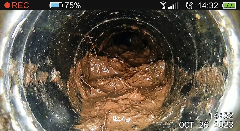 Mud and sediment buildup visible inside a drain
