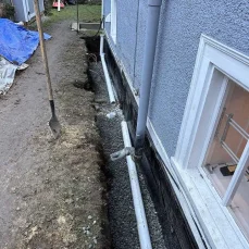 Residential perimeter drainage system protecting home foundations from water damage